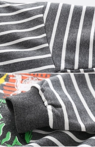 Detail of grey striped cotton sweater featuring ribbed cuffs and colorful graphic print