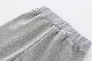 Detail of the elastic ribbed waistband on gray knit cotton children sports trousers