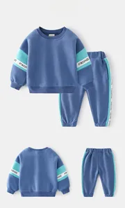 Detail view of boys' blue tracksuit featuring athletic ribbed cuffs and printed side stripes