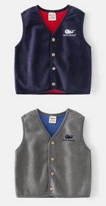 Detail of fleece vest with wooden buttons and cute whale embroidery on the chest