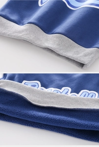 Detail of blue boys' fleece sweatshirt showing thick lining and ribbed hemline
