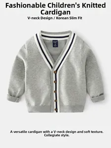 Détail du cardigan gris pour garçon avec col en V, bordures rayées bleu-blanc et boutons bruns