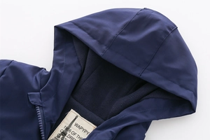 Detail of children's navy hooded jacket showing the warm fleece lining and brand neck label