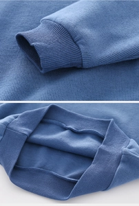 Close-up of ribbed cuffs and hem on blue cotton knit sweatshirt with detailed stitching