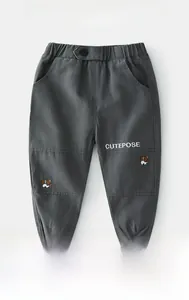 Detail of grey cargo pants for boys with cute dog embroidery and elastic cuffs