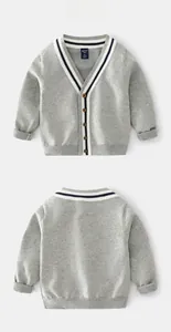 Détail d'un cardigan gris pour enfant avec col en V et bordures rayées noires et blanches