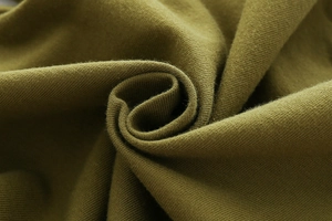 Détail macro de la texture du tissu en coton tricoté vert olive avec plis doux