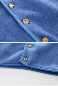 Close-up of blue fleece fabric with textured grain and dark brown wooden buttons