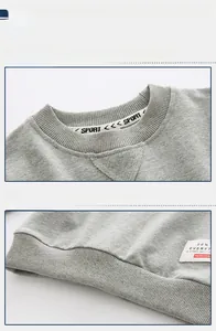 Detail view of the ribbed crewneck and hem with sport logo patch on boys' gray sweatshirt