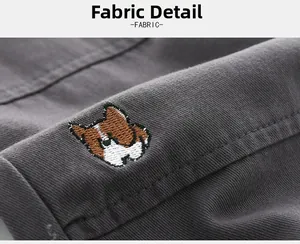Detail macro shot of dark grey twill fabric featuring a cute cartoon dog embroidery