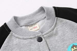 Detail of the boy's jacket neckline showing brand label, size tag, and soft fleece lining