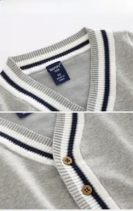 Détail du cardigan gris en maille avec col en V, rayures bleu-blanc et boutons bruns