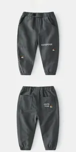 Detail of grey cargo pants for boys with cute dog embroidery and elastic waist cuff