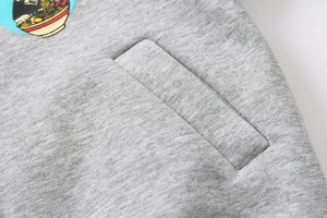 Detail of heather grey knit fabric showing stitching quality and cartoon embroidery