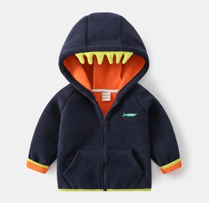 Detail of baby hoodie fleece featuring yellow crocodile teeth hood and orange lining