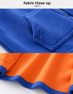 Gros plan sur le tissu polaire orange avec coutures bleues et détails de liseré