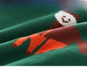 Detailed macro view of green knit fabric with colorful cartoon animal patterns