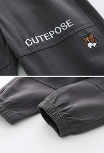 Close-up of boys cargo pants with dog embroidery and elastic cuffs in dark grey