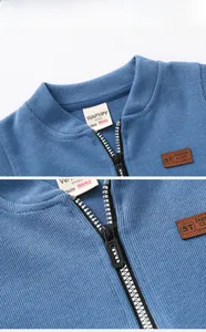 Detail of blue knitted toddler vest with fashion leather patch and smooth zipper close-up