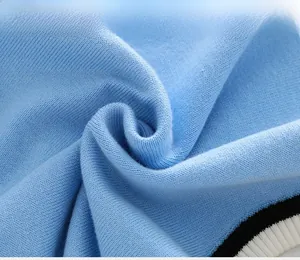 Close-up of light blue knitted fabric texture with black and white ribbed edge detail