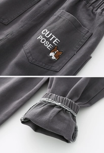 Detail of dark gray kids cargo pants showing cute puppy embroidery and elastic ankle cuffs