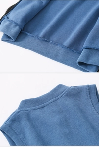 Detail of ribbed hem and neckline on blue knitted kids vest with fine texture