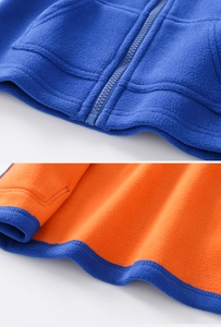 Détail du gilet bleu avec fermeture éclair et doublure en polaire orange contrastée