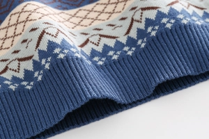 Detail of boys knit sweater featuring Fair Isle geometric pattern and elastic ribbed hem