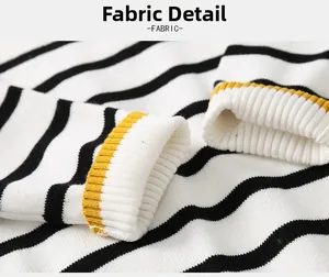 Detailed fabric texture of white and black striped knit sweater with yellow ribbed cuff