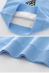 Close-up of ribbed cuffs and tie-pattern jacquard on children's light blue knit vest