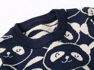 Detail eines dunkelblauen Strickpullovers mit Rundhalsausschnitt und Pandamuster