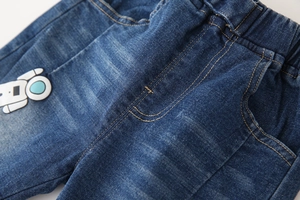 Close-up of boys denim jeans with elastic waistband and embroidered astronaut patch