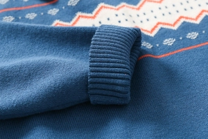 Dettaglio del polsino in maglia a costine spesse di un maglione blu scuro lavorato