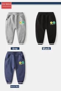 Dettaglio dei pantaloni sportivi in pile per bambini nei colori grigio nero e blu con stampe