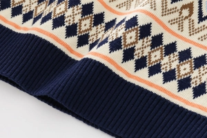 Detail of boys knit sweater showing multi-color argyle pattern and ribbed hem texture