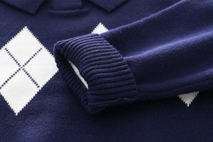 Detail of navy blue knit cardigan with white diamond patterns and ribbed elastic cuffs