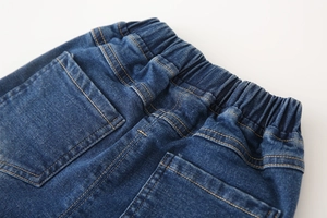Detail view of boys' dark blue denim pants featuring elastic waistband and back pockets