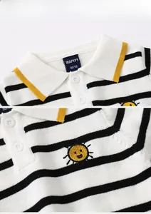 Close-up of baby boy polo sweater with black stripes and yellow sun embroidery details