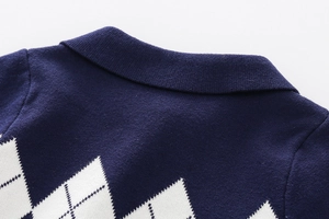 Detail of navy blue argyle knit sweater featuring a classic collar and soft cotton texture