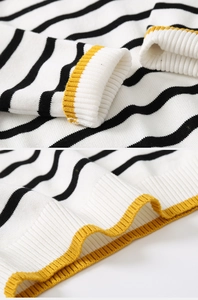 Detail of knitted boys' striped sweater with ribbed cuffs and yellow trim accents
