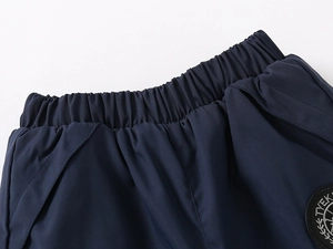 Detailed view of elastic waistband and embroidered logo on navy winter trousers
