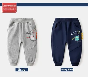 Detail of kids fleece joggers with 3D dinosaur cartoon prints in grey and navy blue