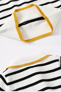 Close-up of black and white striped knit sweater with yellow ribbed cuffs and hem