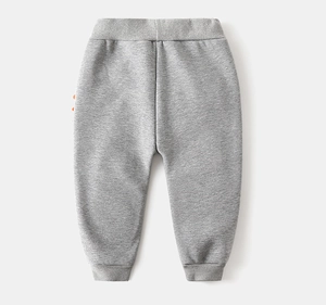 Detail view of grey kids joggers with orange dinosaur spikes and ribbed waistband