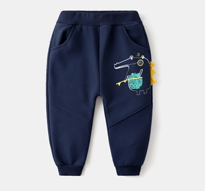 Detail of dark blue kids sports pants featuring cartoon crocodile print and yellow zigzags