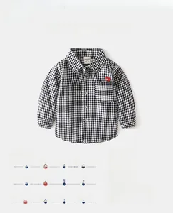 Detailed view of kids cotton shirt featuring black and white gingham with dog embroidery