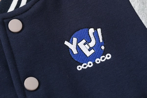 Detail of navy baseball jacket showing fine stitching, ribbed collar, and embroidery