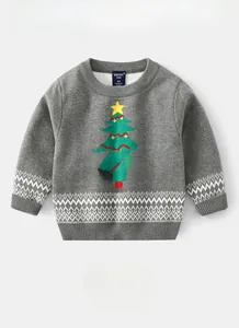 Detail of grey knitted sweater featuring a green Christmas tree motif and white geometric hem