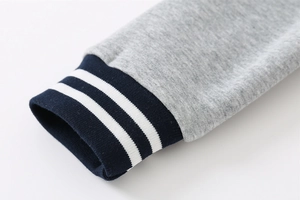 Close-up of heather grey fleece jacket with navy blue striped ribbed elastic cuffs
