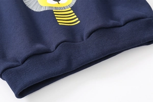 Detail of navy knit cotton hoodie showing ribbed hem and yellow cartoon lion print